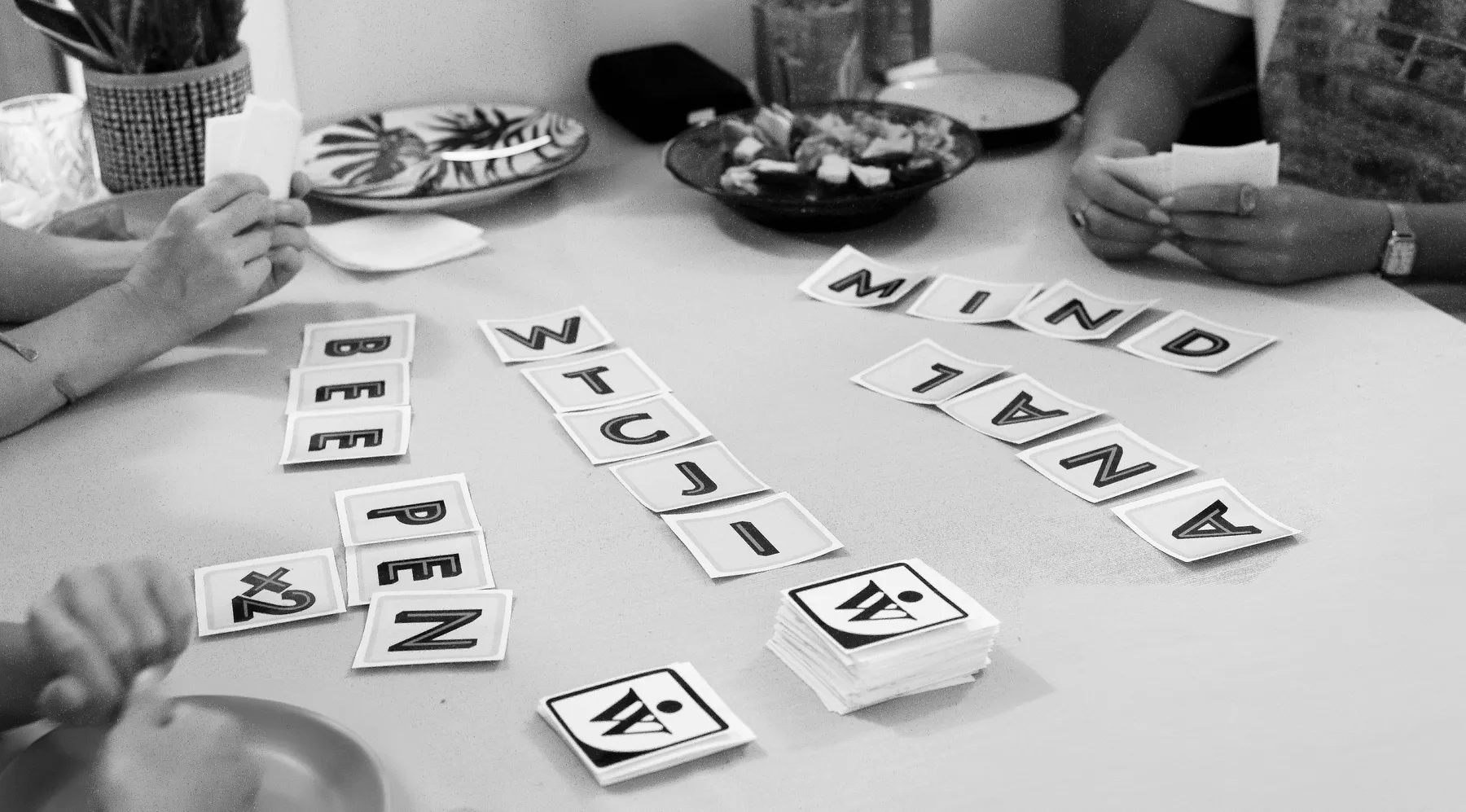 Black and white photograph of Word War One being played on a table with snacks and drinks